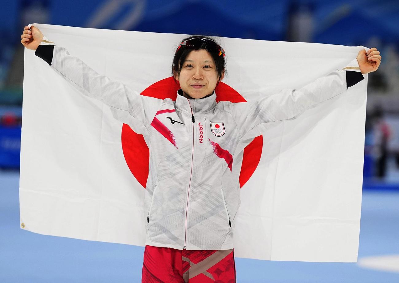 女子1000 メートル で金メダルを獲得し、日の丸を掲げる高木美帆＝北京（共同）