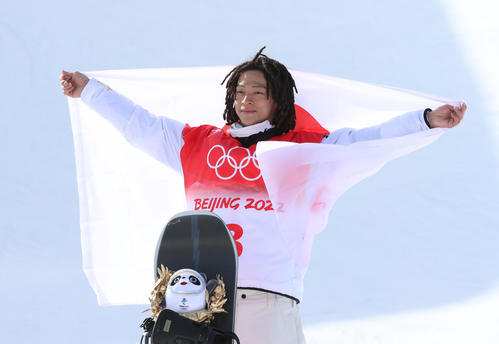 スノーボード男子ハーフパイプで金メダルの平野歩夢は日の丸を掲げ笑顔（撮影・パオロ　ヌッチ）