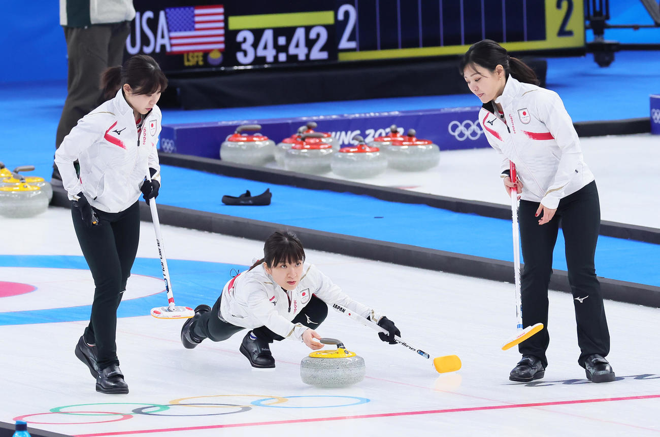 日本対スウェーデン　ストーンを投じる鈴木（中央）。左は吉田夕、右は吉田知（撮影・足立雅史）