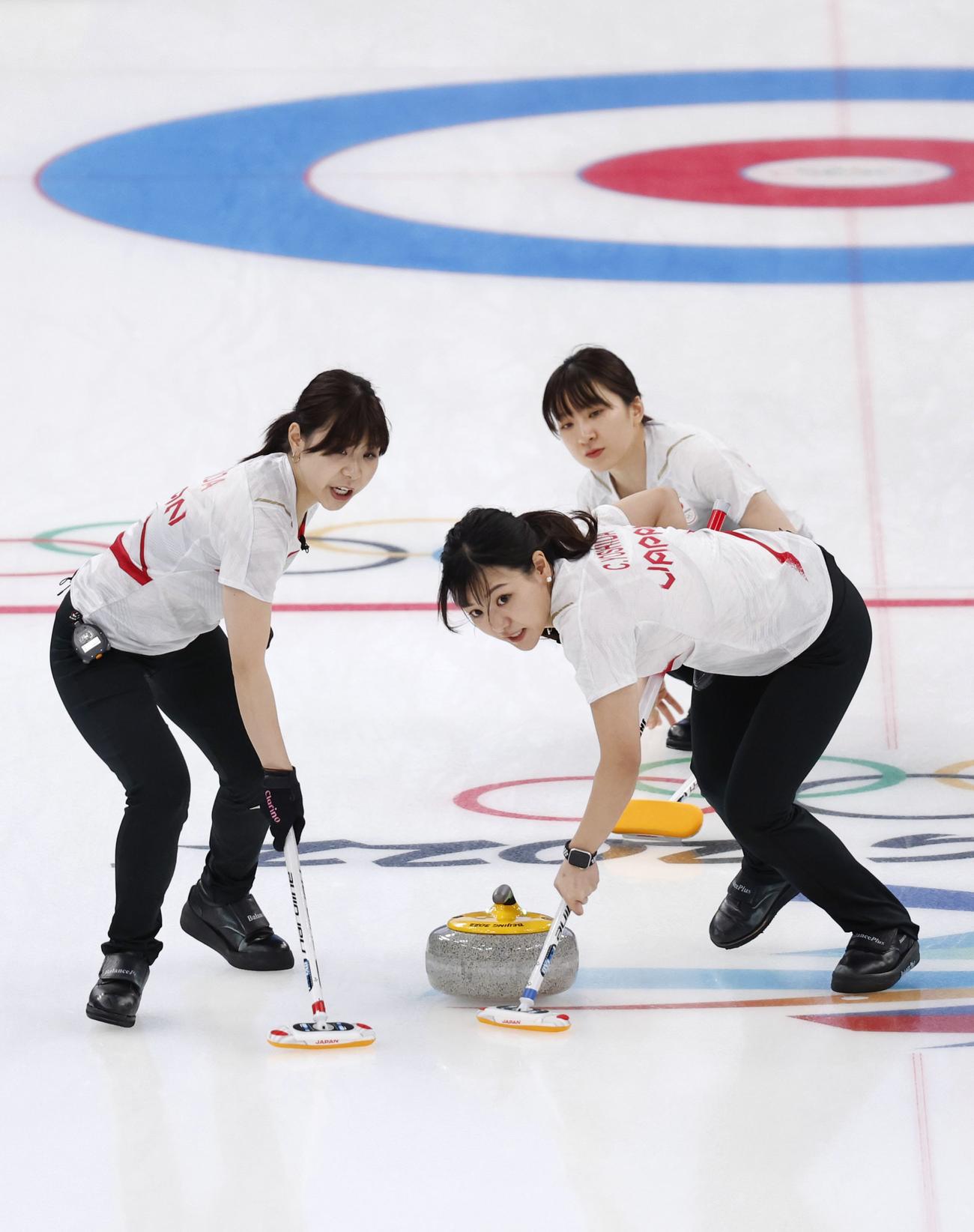 日本―カナダ　第4エンド、スイープする吉田夕（左）と吉田知。奥は鈴木＝北京（共同）