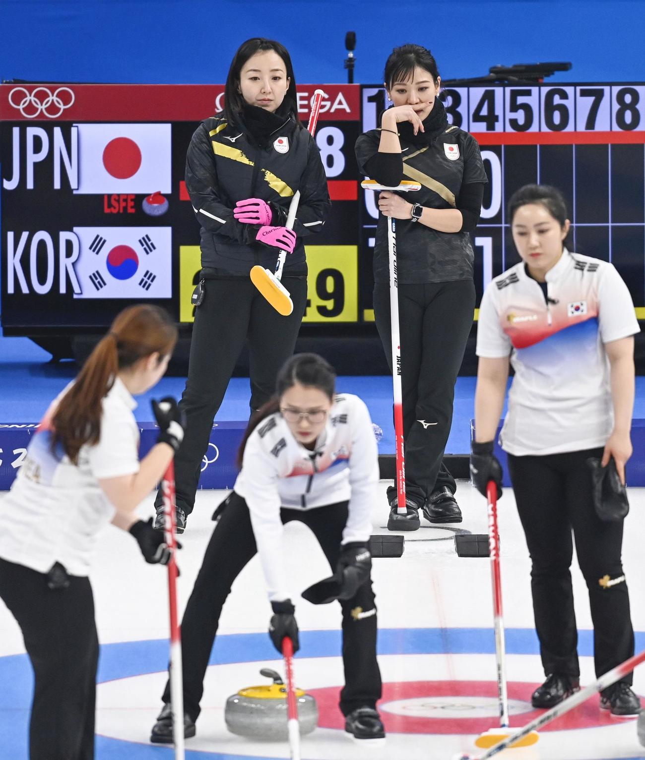 カーリング日本対韓国　第5エンド、試合を見つめる藤沢（奥左）と吉田知（同右）（共同）
