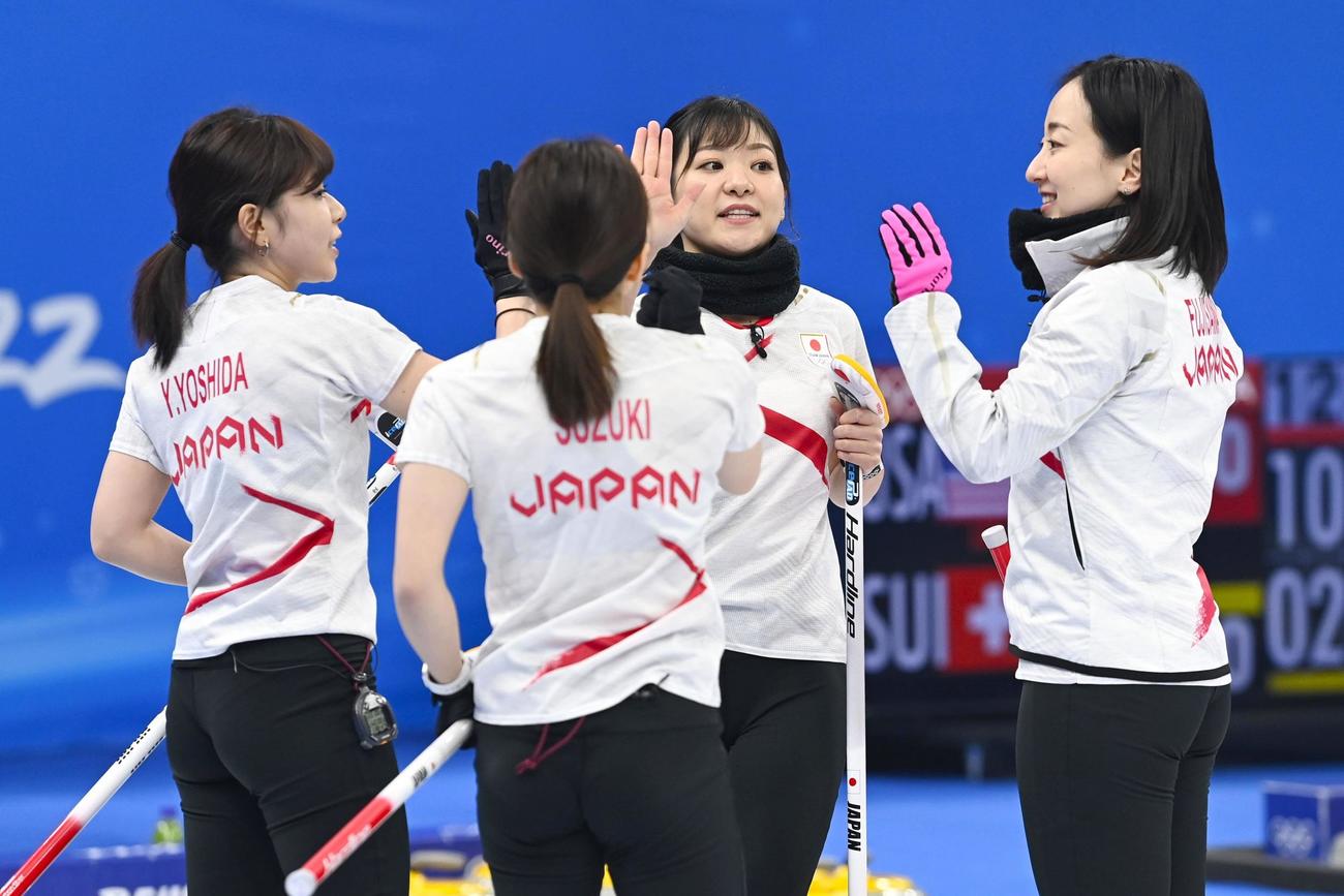 日本―英国　第4エンドに得点を奪い、タッチを交わす（左から）吉田夕、鈴木、吉田知、藤沢＝北京（共同）