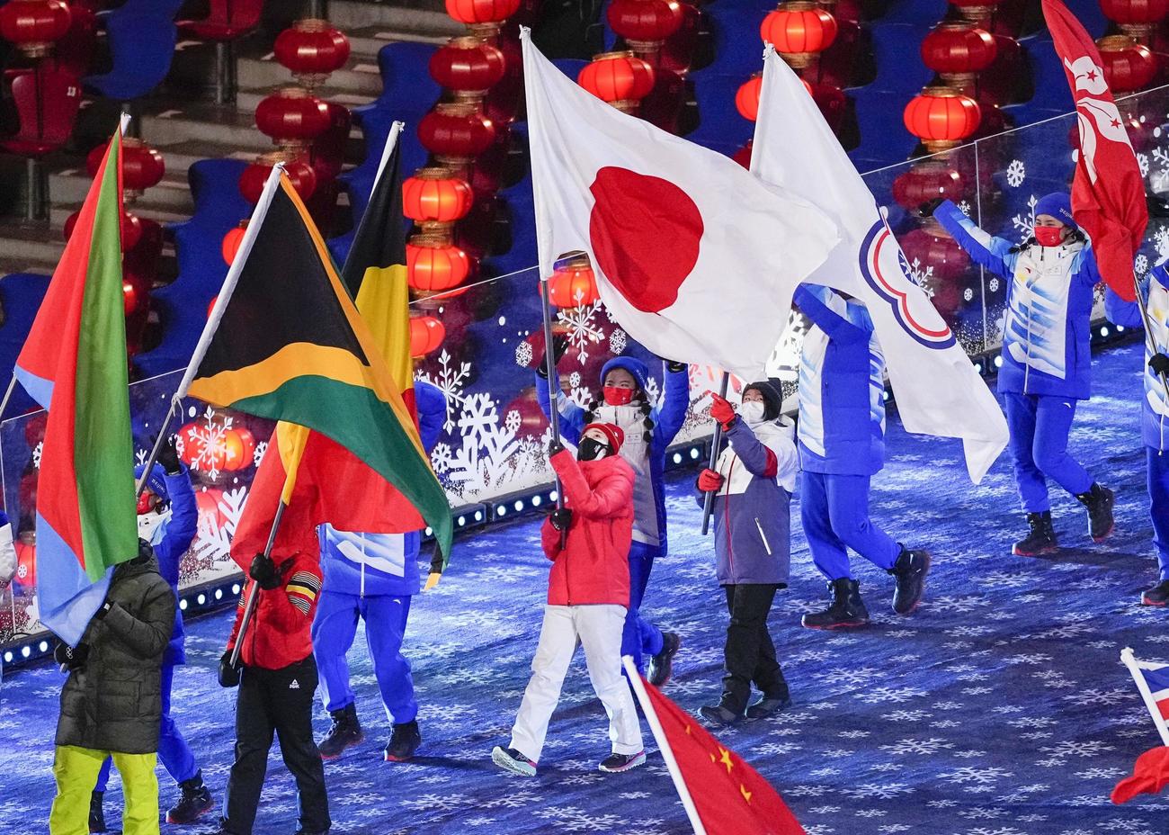 北京冬季五輪の閉会式で、日の丸を掲げ入場行進する旗手の郷亜里砂（中央）（共同）