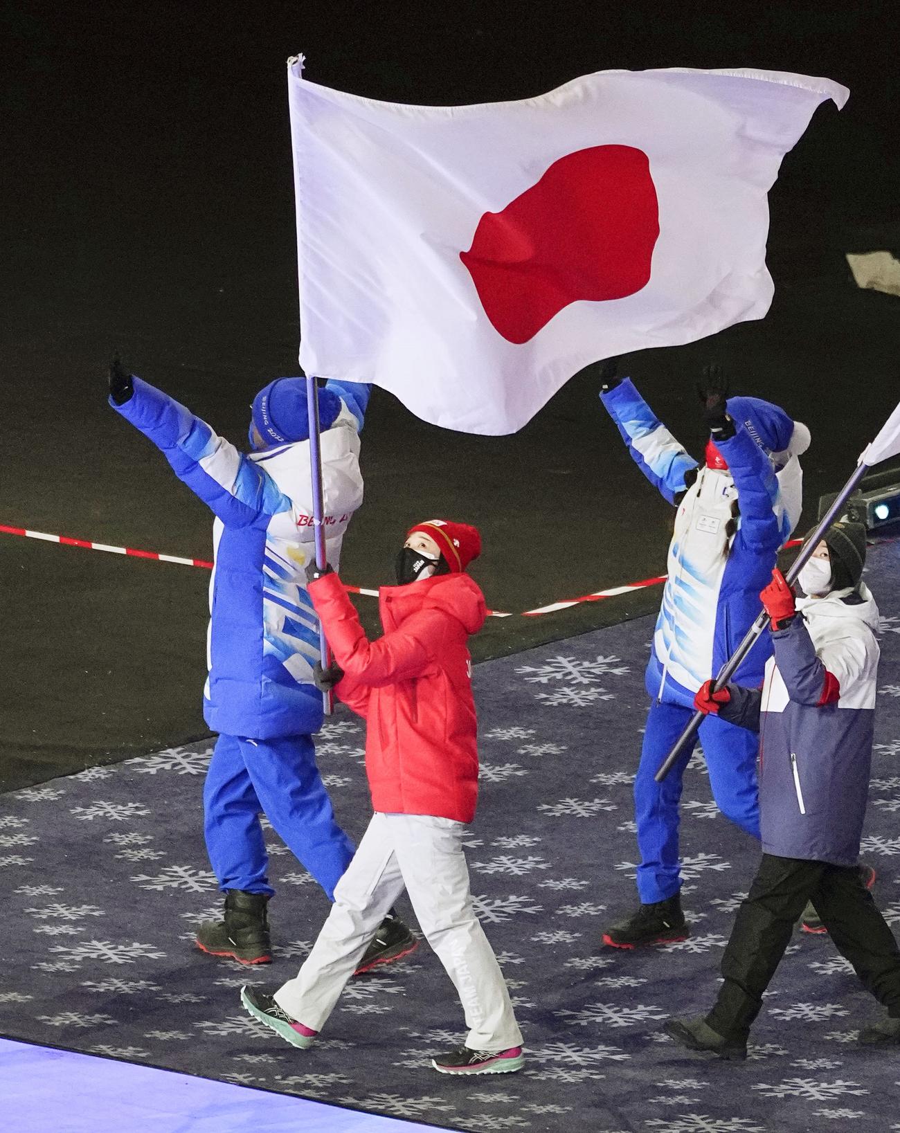 北京冬季五輪の閉会式で、日の丸を掲げ入場行進する旗手の郷亜里砂（共同）
