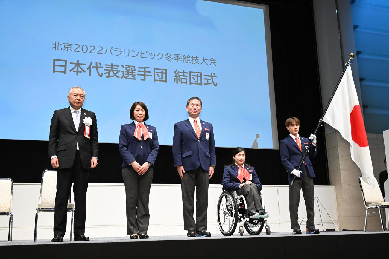 結団式の団旗授与後に記念撮影する、左から公益財団法人日本パラスポーツ協会日本パラリンピック委員会森和之会長、桜間裕子副団長、河合純一団長、村岡主将、川除旗手（撮影・滝沢徹郎）