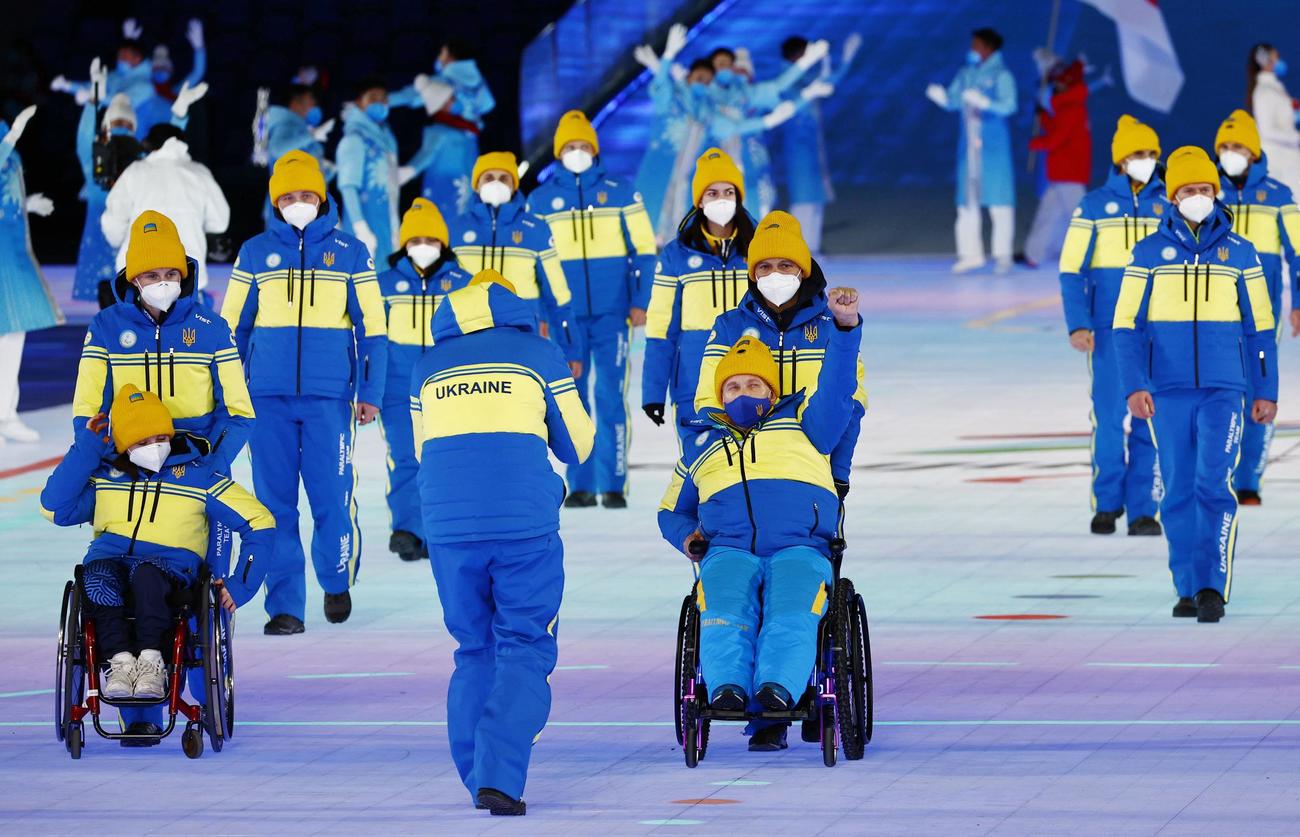 北京冬季パラリンピックの開会式で、入場行進するウクライナ選手団。拳を突き上げる人もいた（共同）