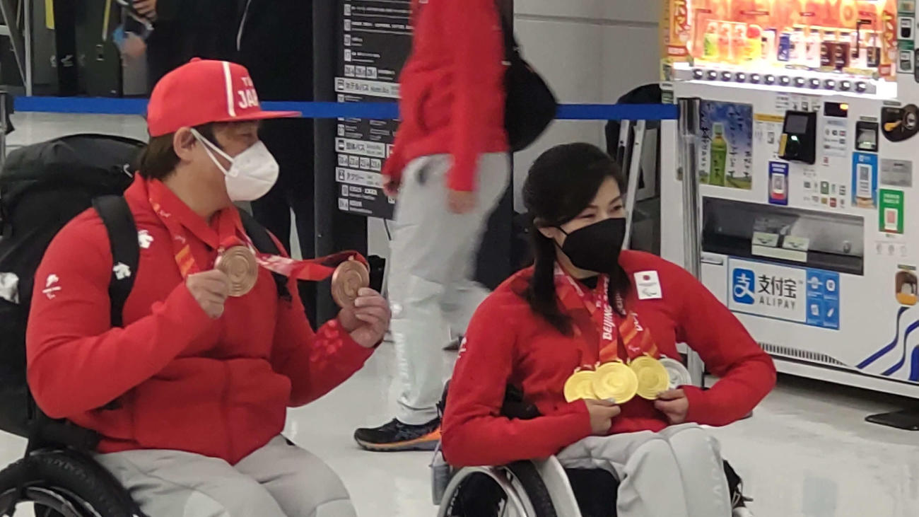 獲得したメダルを掲げて笑顔の帰国を果たした森井（左）と村岡（撮影・平山連）