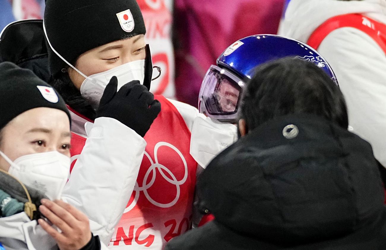 女子個人ノーマルヒルで4位に終わり、チーム関係者と抱き合う高梨沙羅（右）（共同）