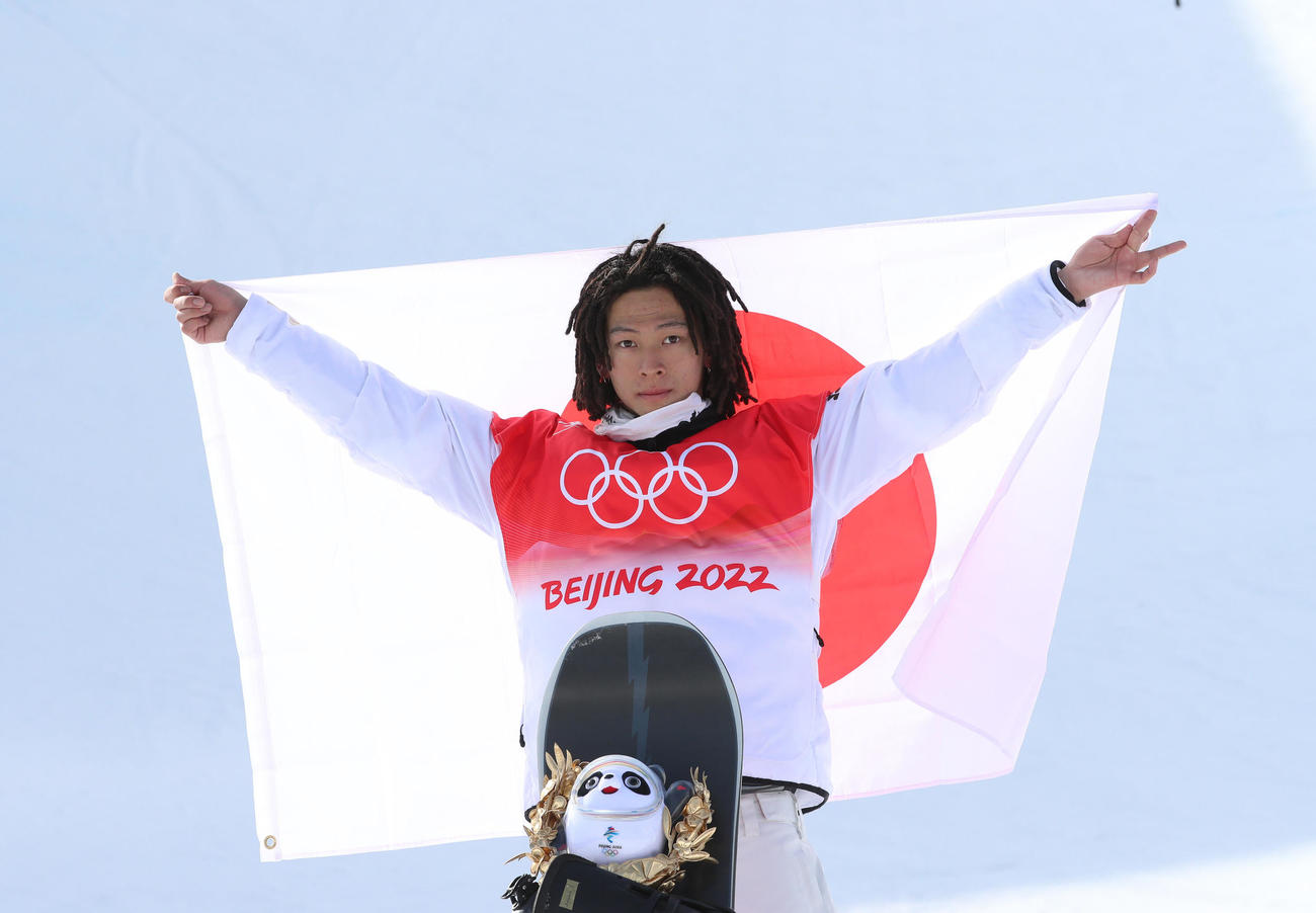 スノーボード男子ハーフパイプで金メダルを獲得した平野歩は日の丸を掲げる（撮影・パオロ　ヌッチ）