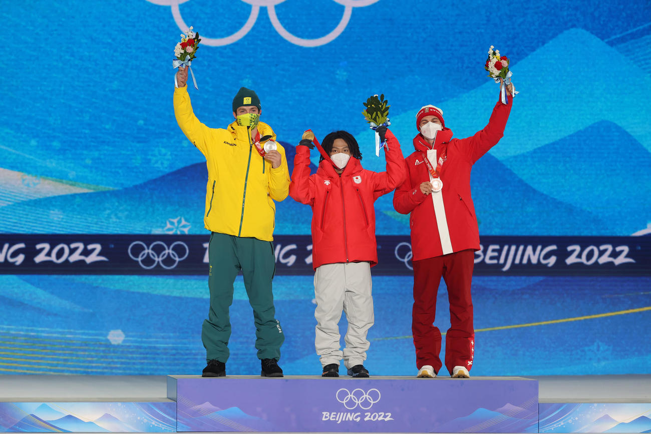 スノーボード男子ハーフパイプのメダルセレモニーで金メダルを掲げる平野歩。左は銀メダルのスコット・ジェームズ、右は銅メダルのヤン・シェレル（撮影・パオロ　ヌッチ）