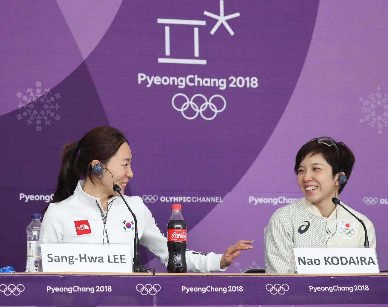 女子500メートルを終え、会見で笑い合う小平（右）と李相花＝2018年2月18日