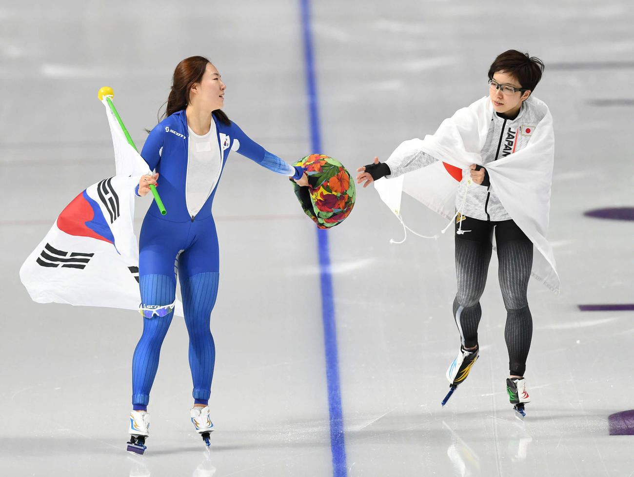 女子500メートル　金メダルの小平（右）は銀メダルの李相花から帽子を受け取る女子500メートル　