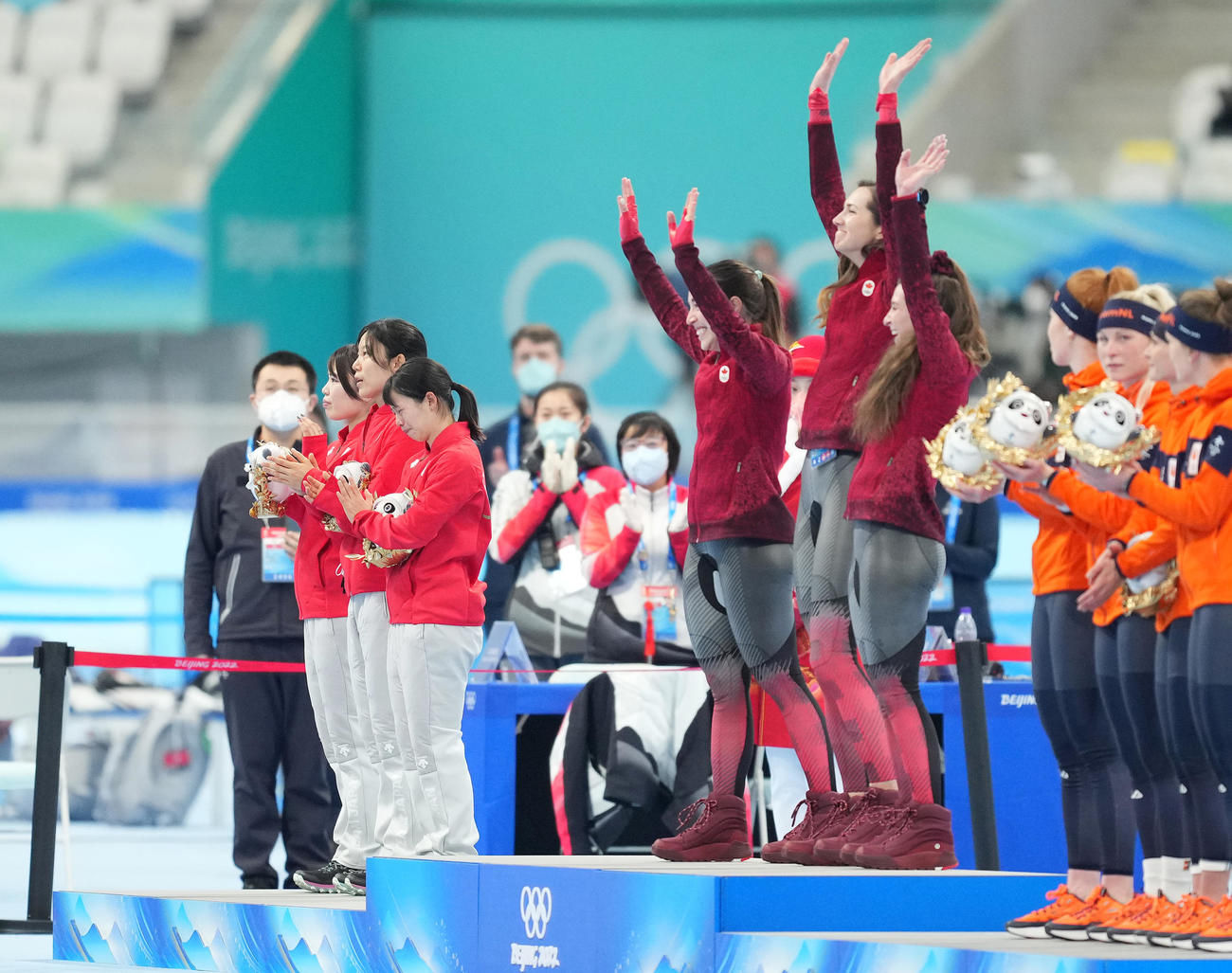 スピードスケート女子団体追い抜きで銀メダルに終わり、金メダルに喜ぶカナダの選手たちの横で肩を落とす高木菜（左から4人目）ら（撮影・菅敏）