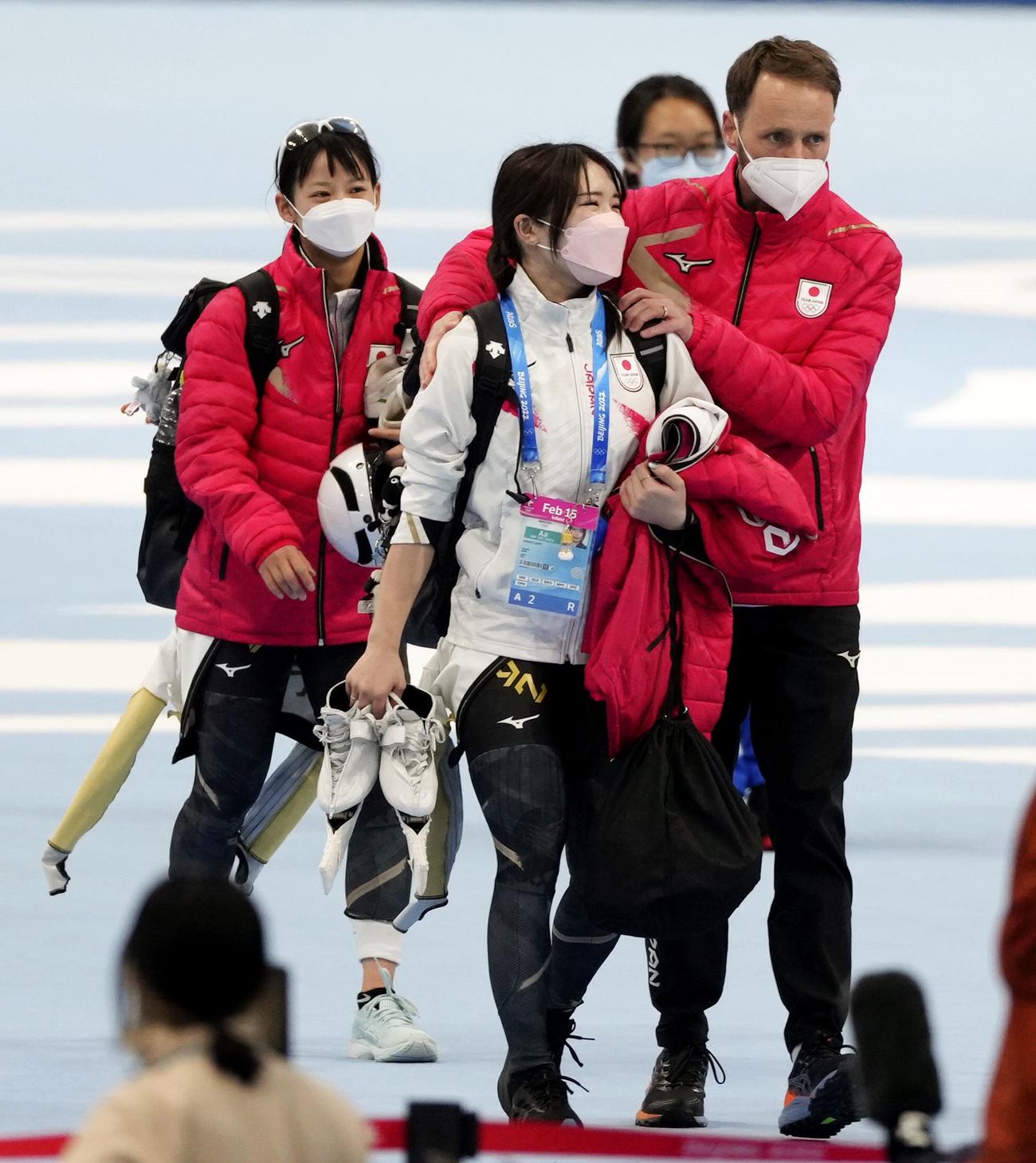 女子団体追い抜き準決勝のレースを終え、ヨハン・デビット・コーチ（手前右）と引き揚げる佐藤綾乃。奥左は高木菜那（共同）