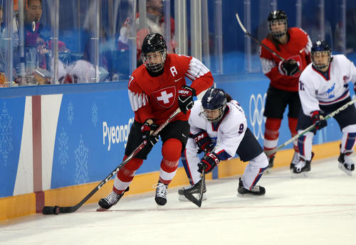 アイスホッケー女子　スイスの選手と競り合う韓国と北朝鮮による合同チーム「コリア」の選手