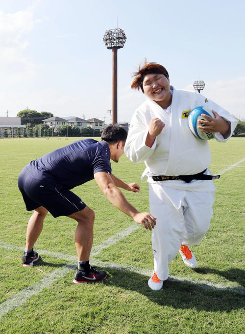持参したラグビーシューズを履き、福岡（左）のタックルをかわす朝比奈（撮影・垰建太）