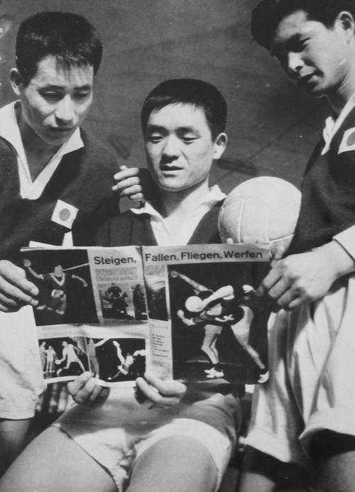 世界選手権初出場のドイツで地元雑誌に見入る日本代表の田口侑義氏(中央)。左は佐藤宏輔氏、右は主将の竹野泰昭氏
