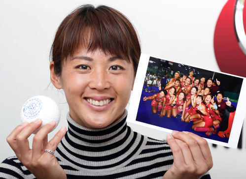 「女子ホッケーをもっとたくさんの人々に知ってほしい」。アジア大会優勝時の写真とボールを手に笑顔を見せる小野真由美(撮影・浅見桂子)