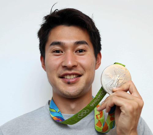 飯塚はリオ五輪の陸上男子400メートルリレーで獲得した銀メダルを手に笑顔を見せる(撮影・松本俊)