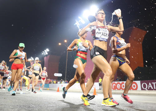 【写真1】19年9月、世界陸上ドーハ大会の女子20キロ競歩、レース中に頭から水をかぶる岡田（右手前）