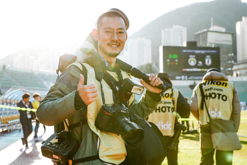サッカー東アジアE－1選手権でソニーとニコンのカメラを手にする加藤諒カメラマン