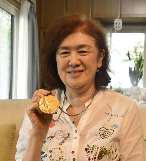 76年モントリオール五輪バレーボール女子で獲得した金メダルを掲げる田村（旧姓・前田）悦智子さん（撮影・平山連）