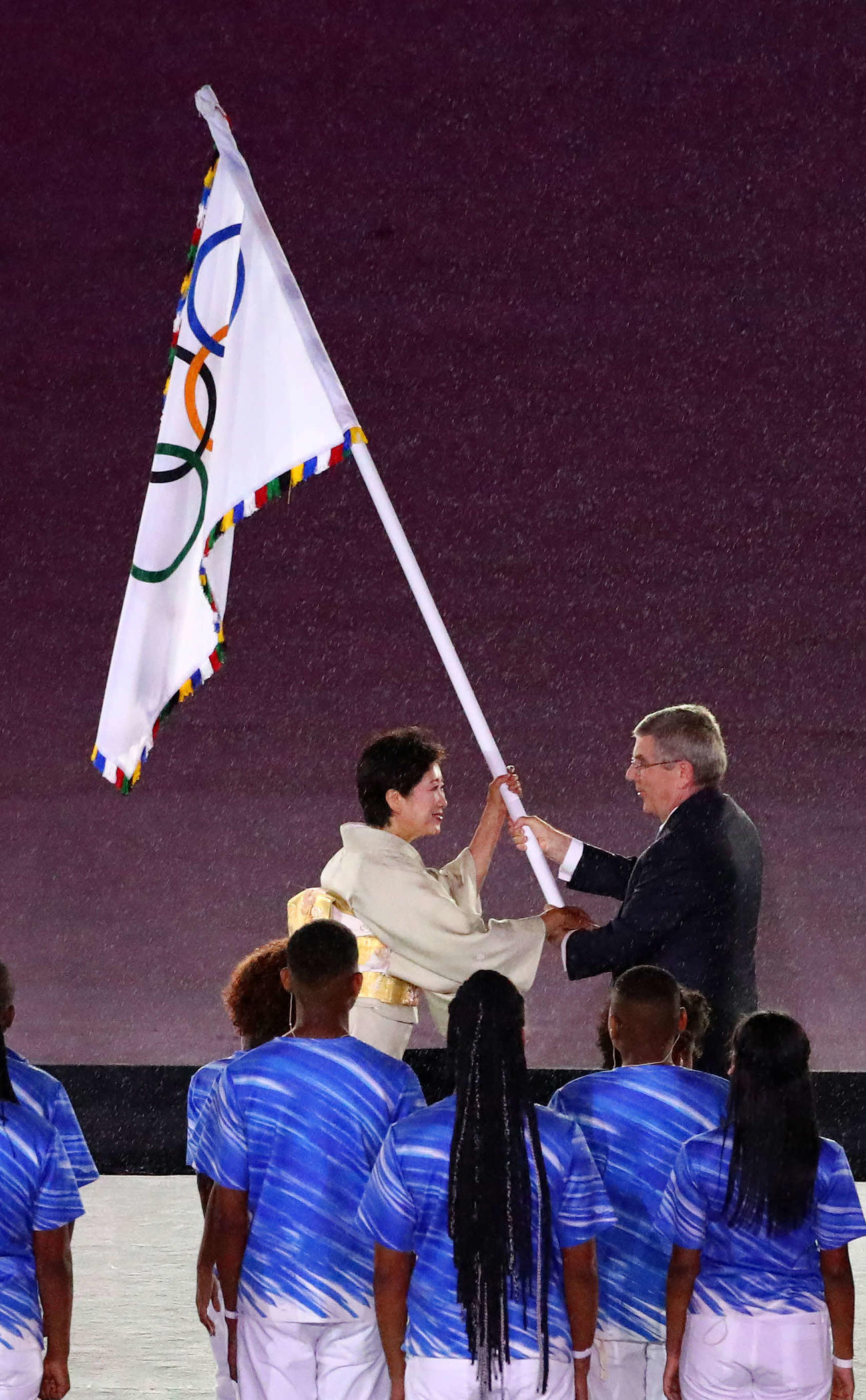 16年8月、リオデジャネイロ五輪閉会式でIOCのバッハ会長（右）から五輪旗を受け取る小池百合子東京都知事