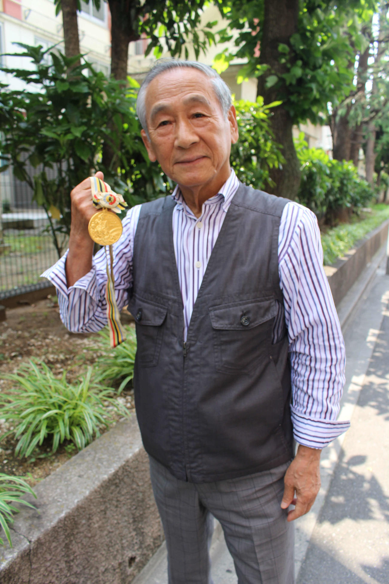 64年東京五輪レスリングでフライ級金メダリストとなった吉田義勝さんはメダルを手にする