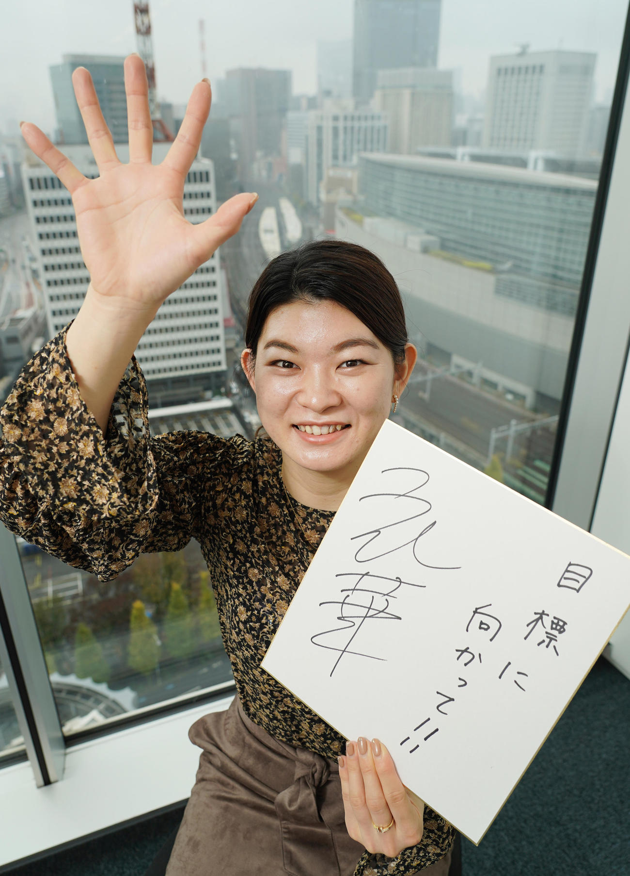 東京五輪出場選手へ応援メッセージを書いた色紙を手にパワーを送る高橋礼華さん（撮影・菅敏）