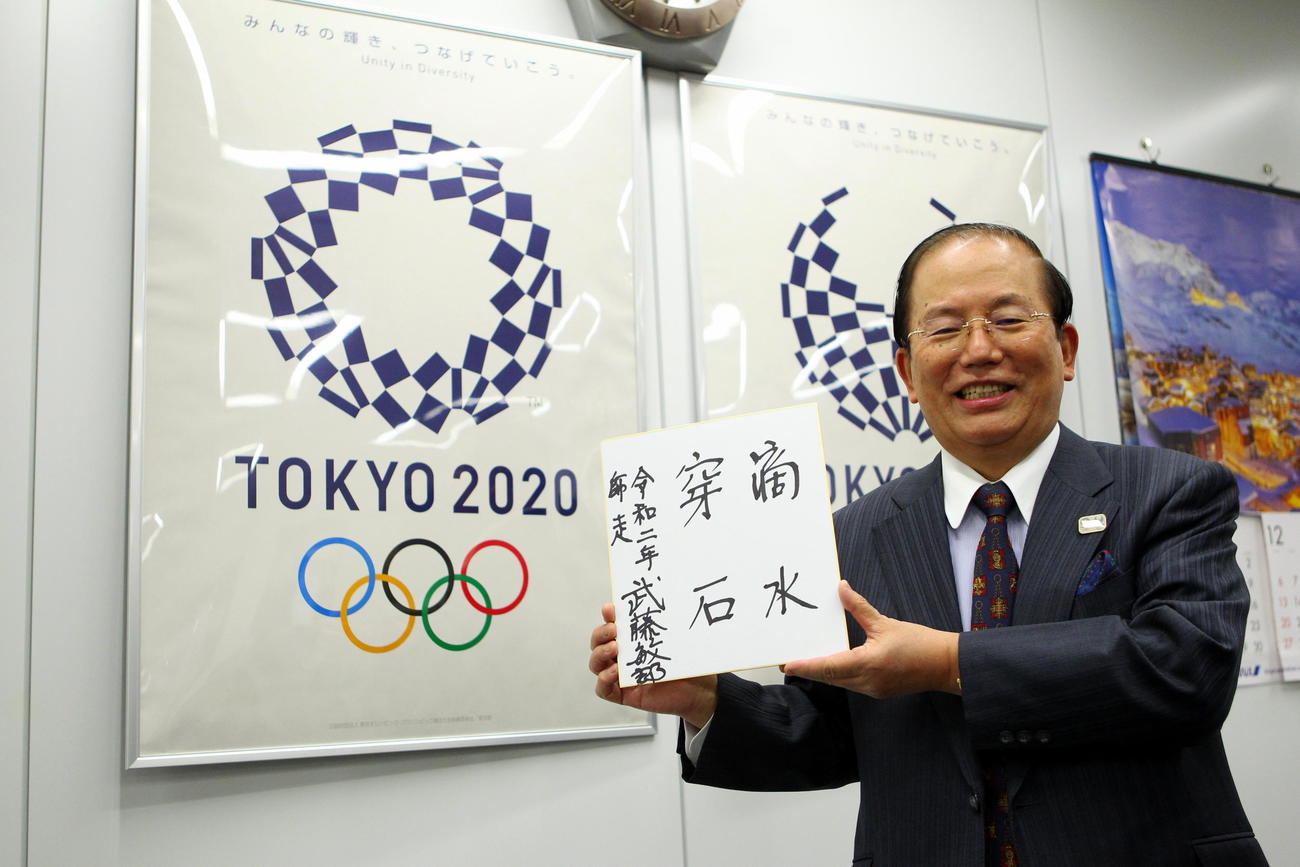 座右の銘「滴水穿石」を手に笑顔を見せる武藤事務総長（撮影・三須一紀）