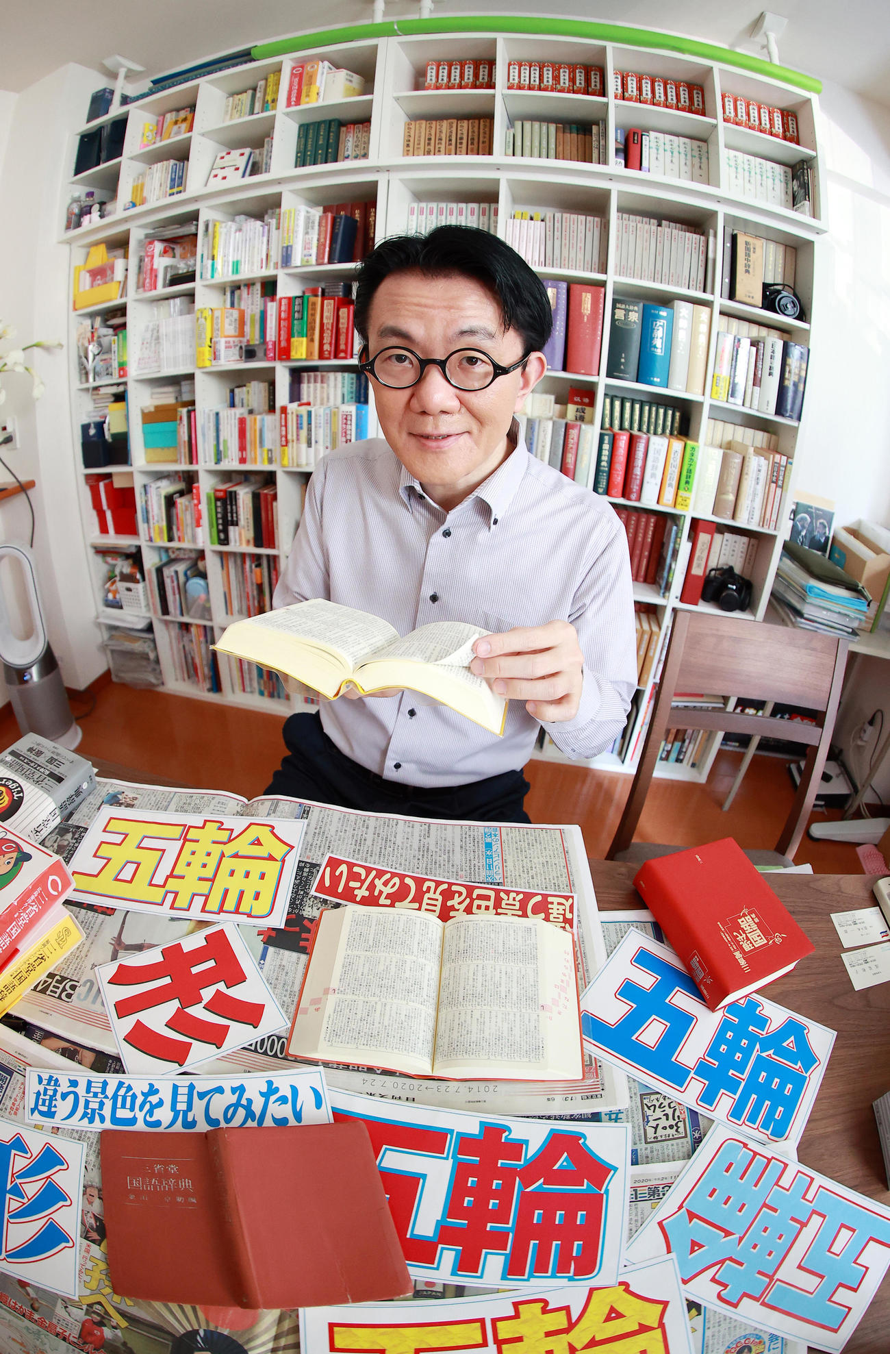 五輪やスポーツにおいての「言葉」について語りながら辞典を調べる国語辞典編纂（へんさん）者の飯間浩明氏（撮影・浅見桂子）