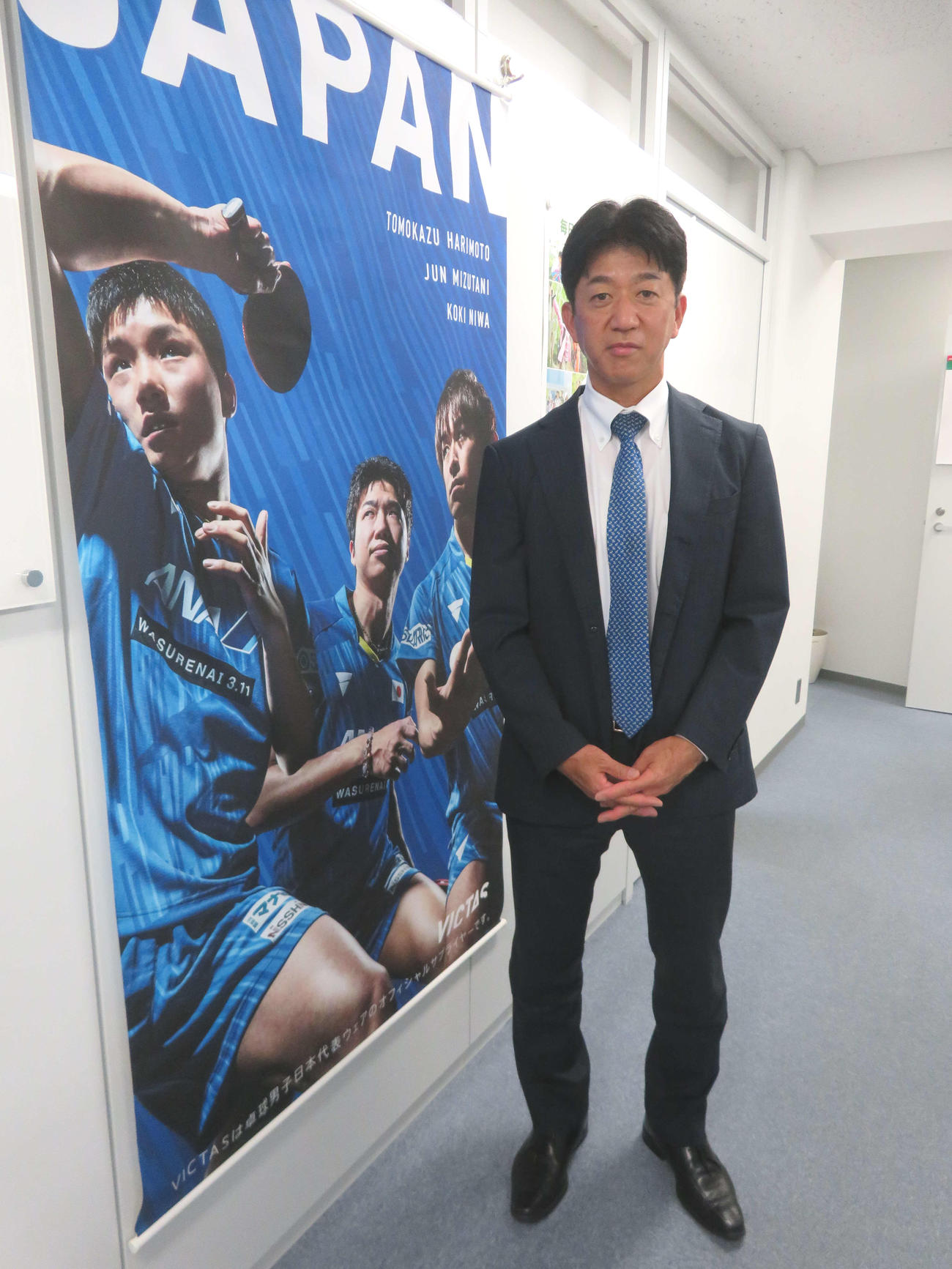東京五輪の男子代表のポスターを前にする松下浩二氏（撮影・三須一紀）