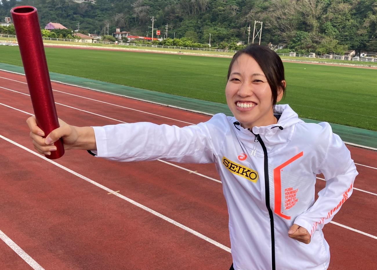 バトンを持ち笑顔を見せる陸上女子短距離の福島千里