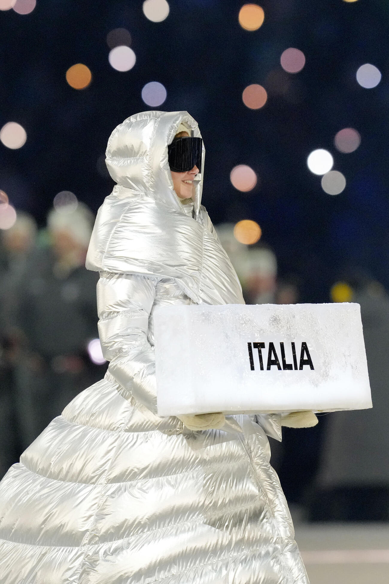 開会式で入場行進するイタリア選手団を先導する女性（代表撮影）
