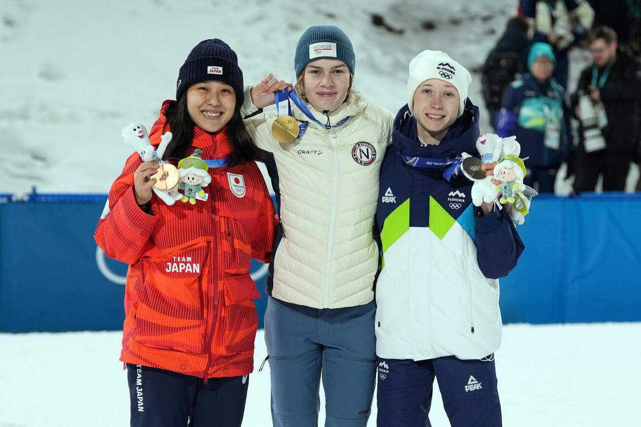 女子ノーマルヒル決勝　銅メダルを獲得した丸山希（左）。中央は金メダルのアンナオディネ・ストレム、右は銀メダルのニカ・プレブツ（撮影・パオロ　ヌッチ）
