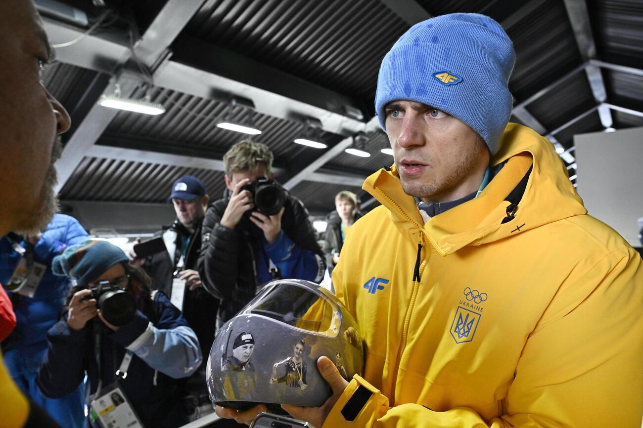 失格決定を受け、ヘルメットを手に取材に応じるミラノ・コルティナ冬季五輪スケルトン男子ウクライナ代表のウラジスラフ・ヘラスケビッチ＝12日、イタリア・コルティナダンペッツォ（共同）