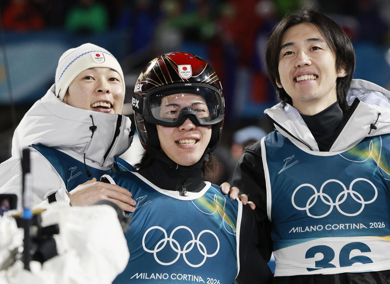 男子個人ラージヒルの2回目の飛躍を終え、小林陵侑（左）、中村直幹（右）と得点を確認して笑顔を見せる二階堂蓮。銀メダルを獲得した＝プレダッツォ（共同）