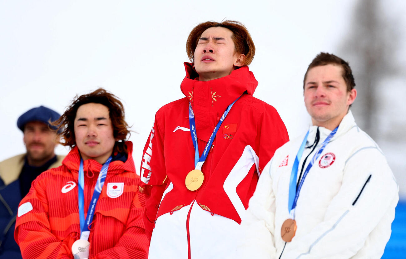 金メダリストの中国の蘇翊鳴が、銀メダリストの日本の長谷川帝勝、銅メダリストのアメリカのジェイク・カンターとともに表彰台で喜びを分かち合う（ロイター）
