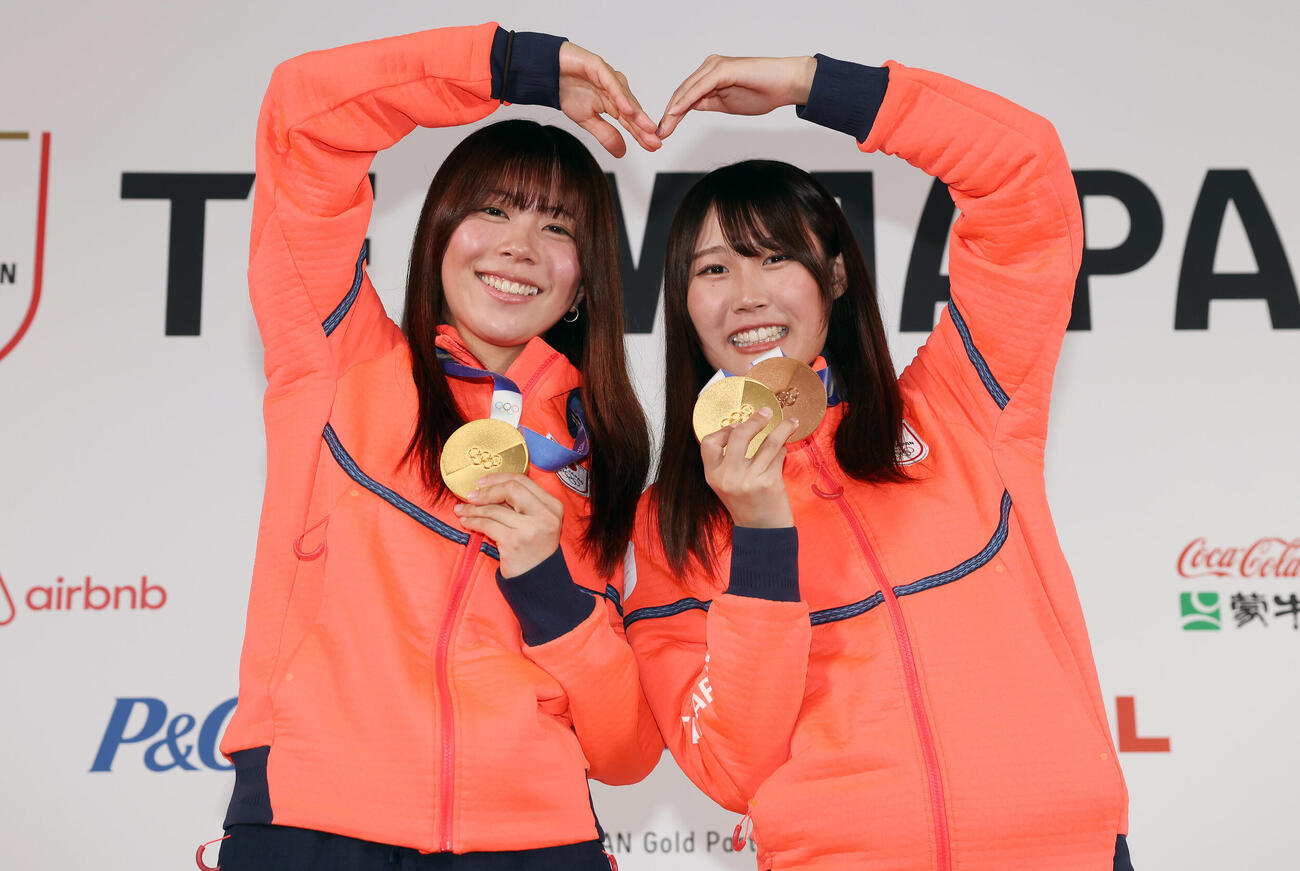 メダリスト会見でメダルを手にハートポーズをつくる深田（左）と村瀬（2026年2月20日撮影）