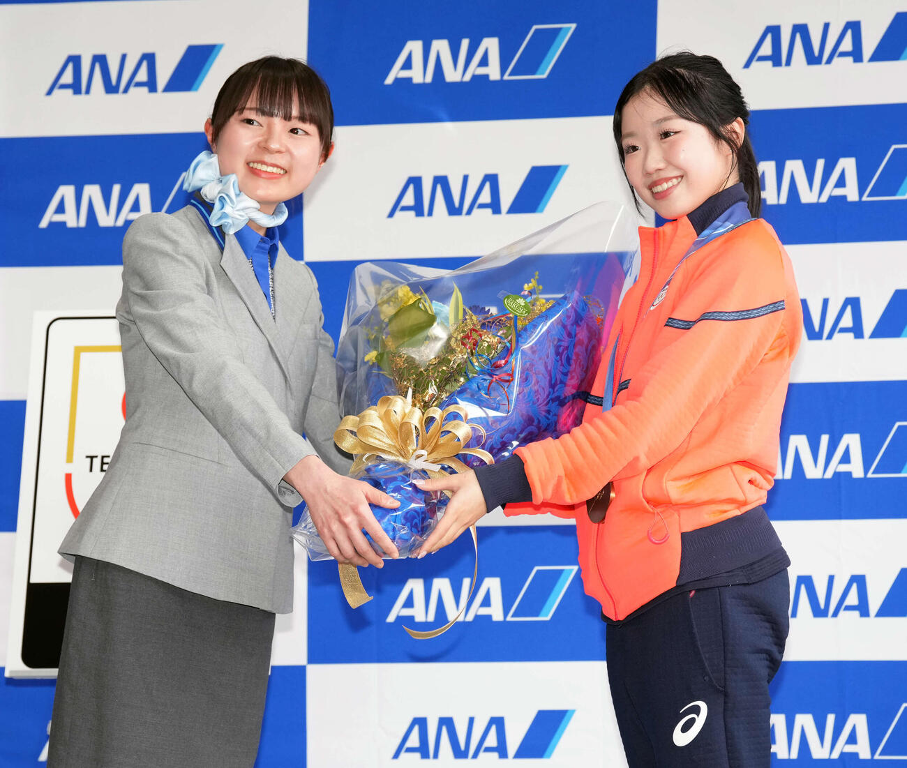 帰国し花束を受け取る女子フィギュアスケートの中井（右）（撮影・小島史椰）