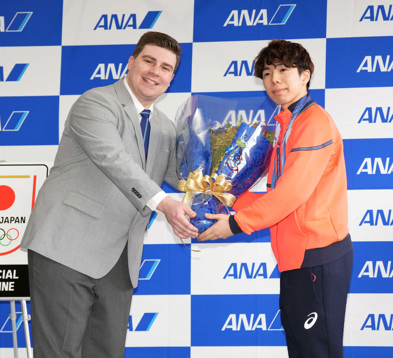 帰国し花束を受け取る男子フィギュアスケートの佐藤（右）（撮影・小島史椰）