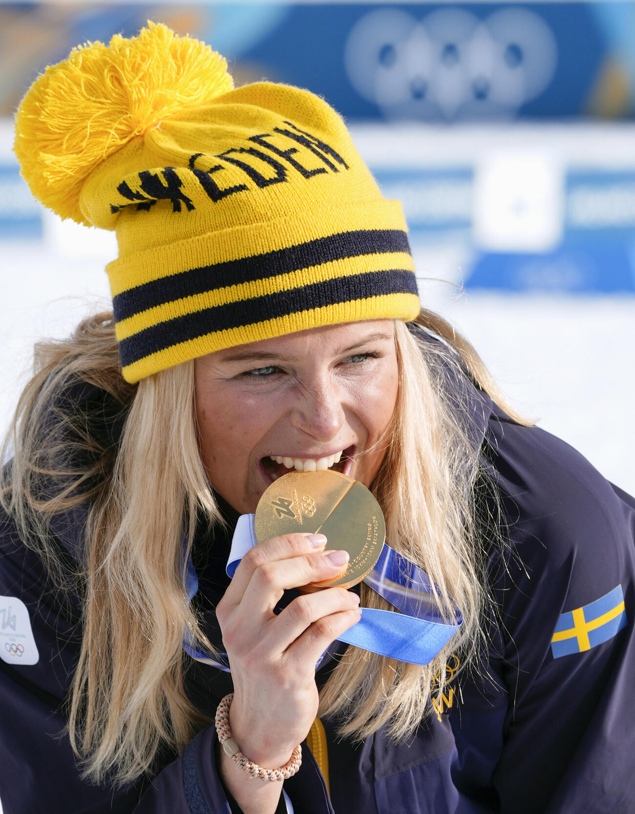 女子距離複合で優勝し、金メダルをかじるスウェーデンのフリダ・カールソン＝テーゼロ（共同）