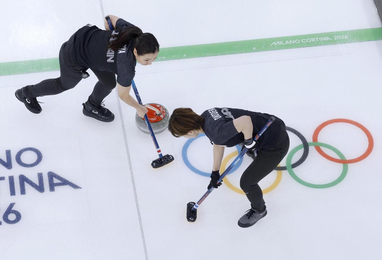 日本―スウェーデン　第8エンド、スイープする近江谷（左）と小野寺＝コルティナダンペッツォ（共同）