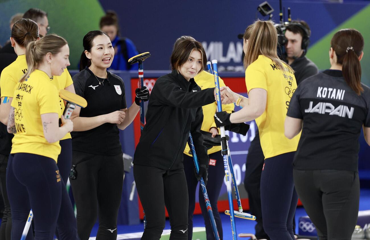 試合終了後、スウェーデン選手と健闘をたたえ合う吉村（中央）ら＝コルティナダンペッツォ（共同）