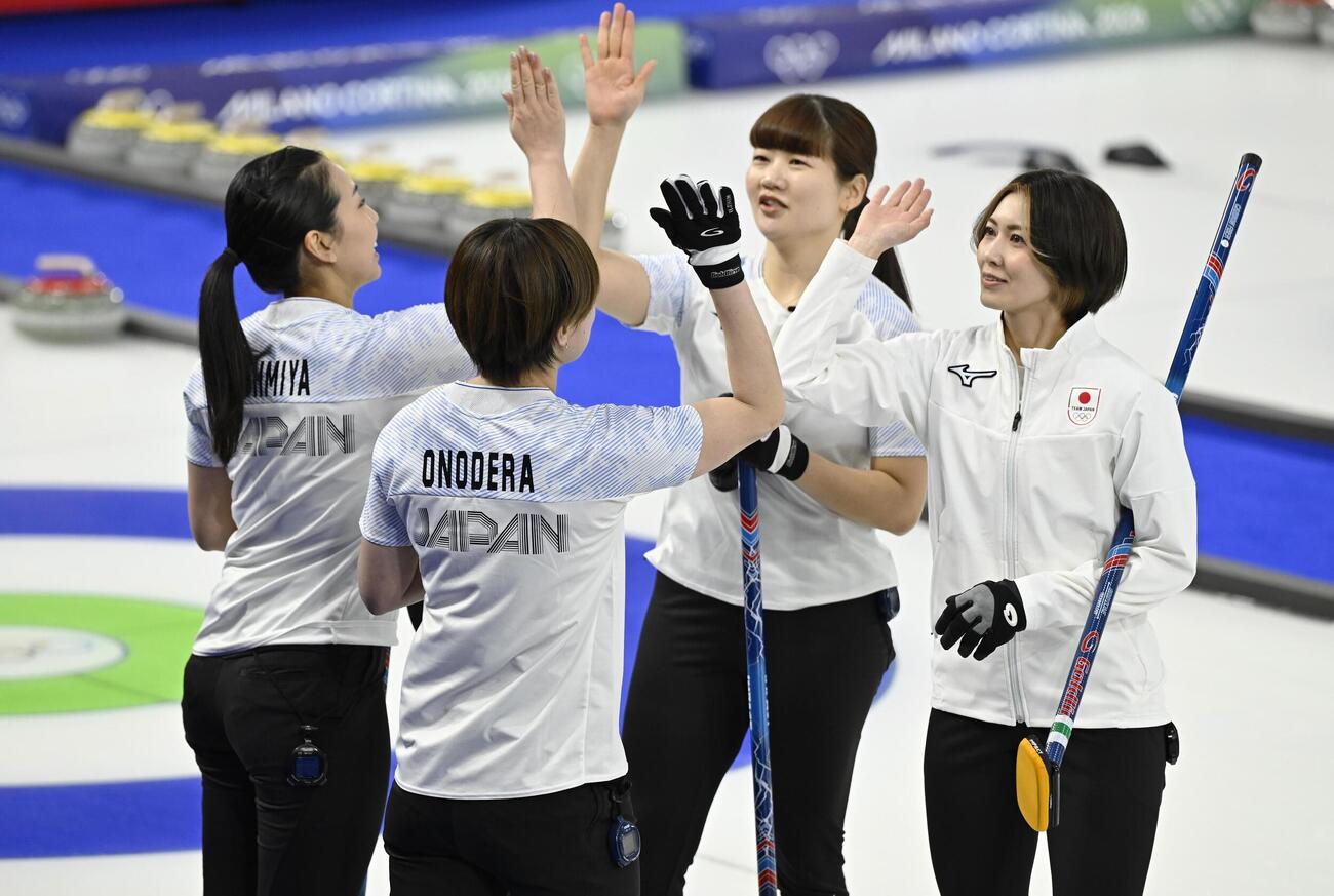 日本―スイス　第4エンド、同点に追い付きタッチを交わす（右から）吉村、小谷ら＝コルティナダンペッツォ（共同）