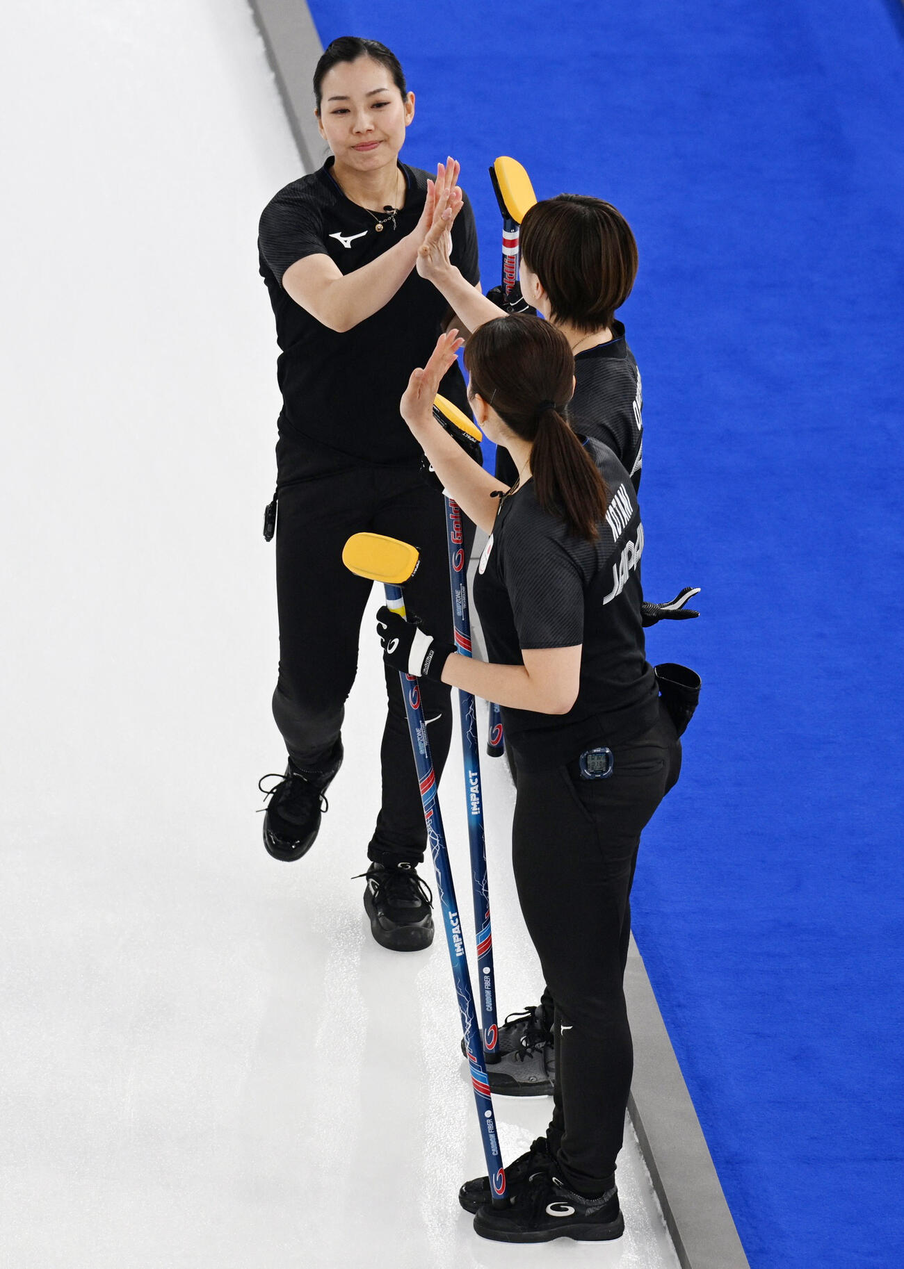 カーリング女子１次Ｌ　日本ー米国　チームメートとハイタッチをする、日本代表フォルティウス近江谷杏菜（ロイター）