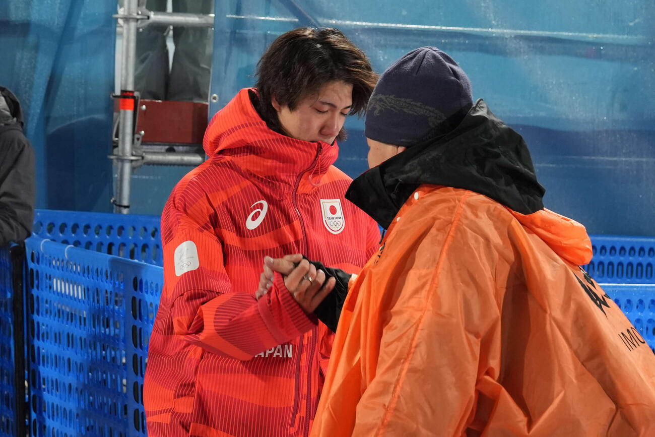 銀メダルの二階堂（左）は浮かない表情で父の学さんと握手を交わす（撮影・パオロ　ヌッチ）