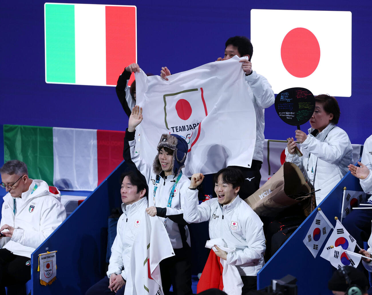 吉田、森田組が入場し、声援を送る鍵山（手前右）と佐藤（同中央）ら日本の選手たち（撮影・前田充）
