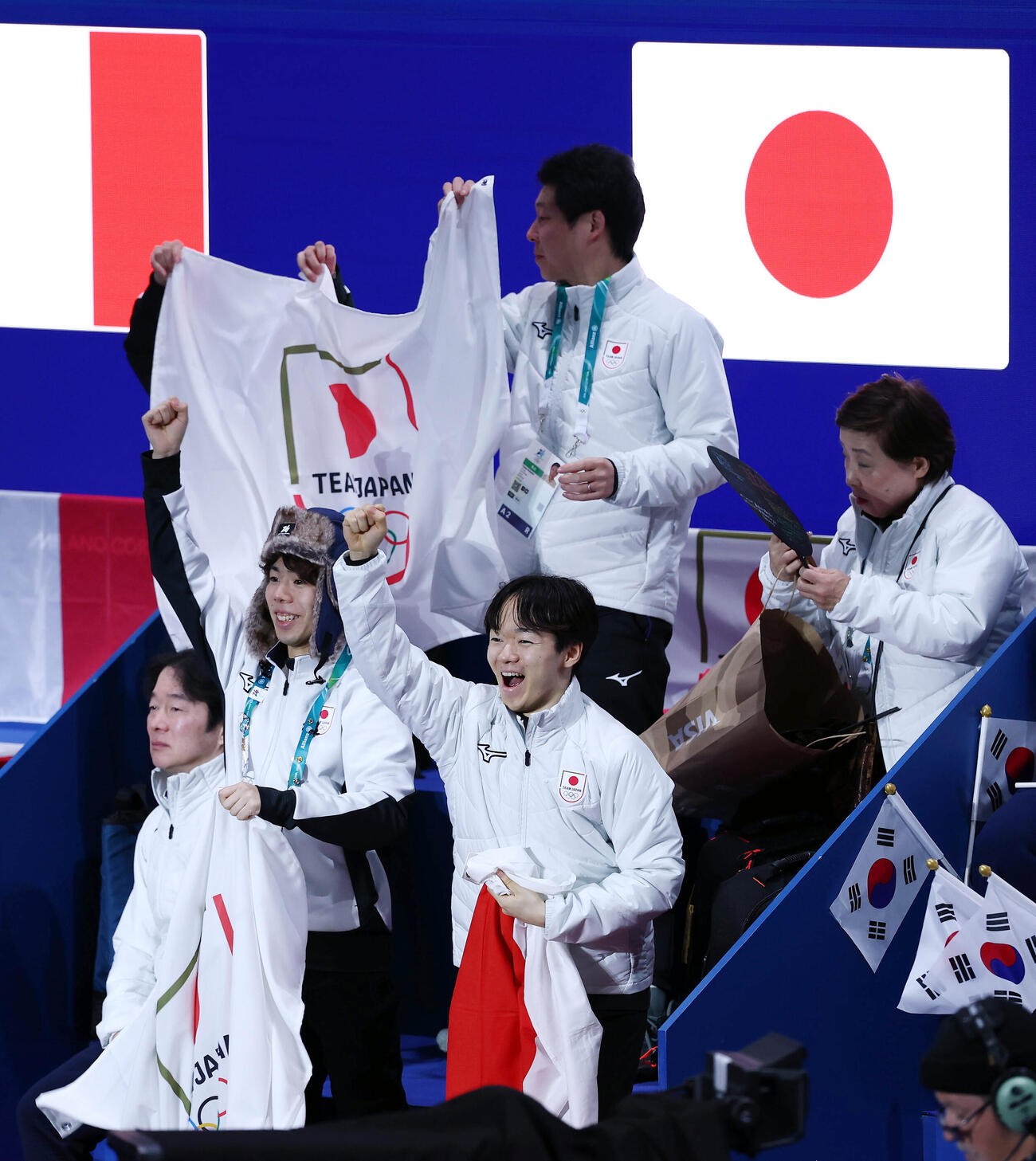 吉田、森田組が入場し、声援を送る鍵山（手前右）と佐藤（同中央）ら日本の選手たち（撮影・前田充）