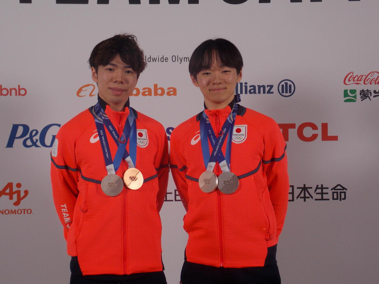 日本オリンピック委員会（JOC）のメダリスト記者会見で笑顔を見せる鍵山優真（右）と佐藤駿（撮影・松本航）